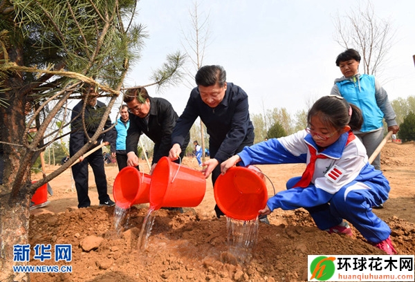 习近平同大家一起给刚栽下的树苗浇水